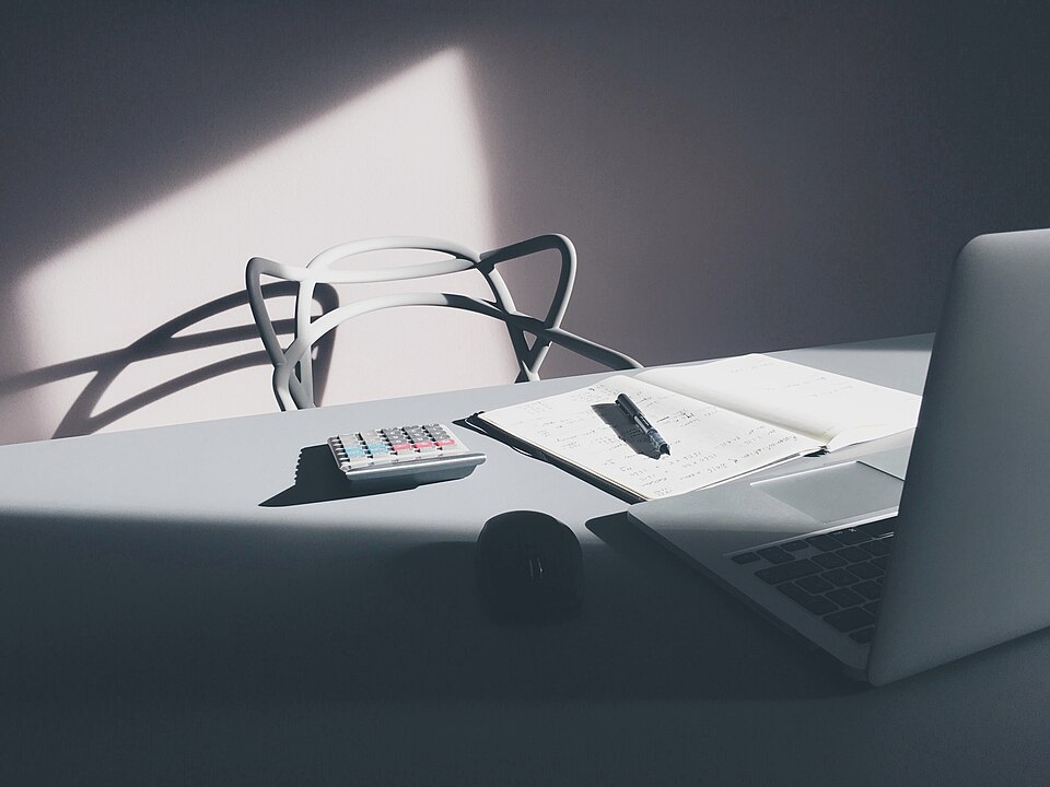Escritorio con portátil y calculadora.