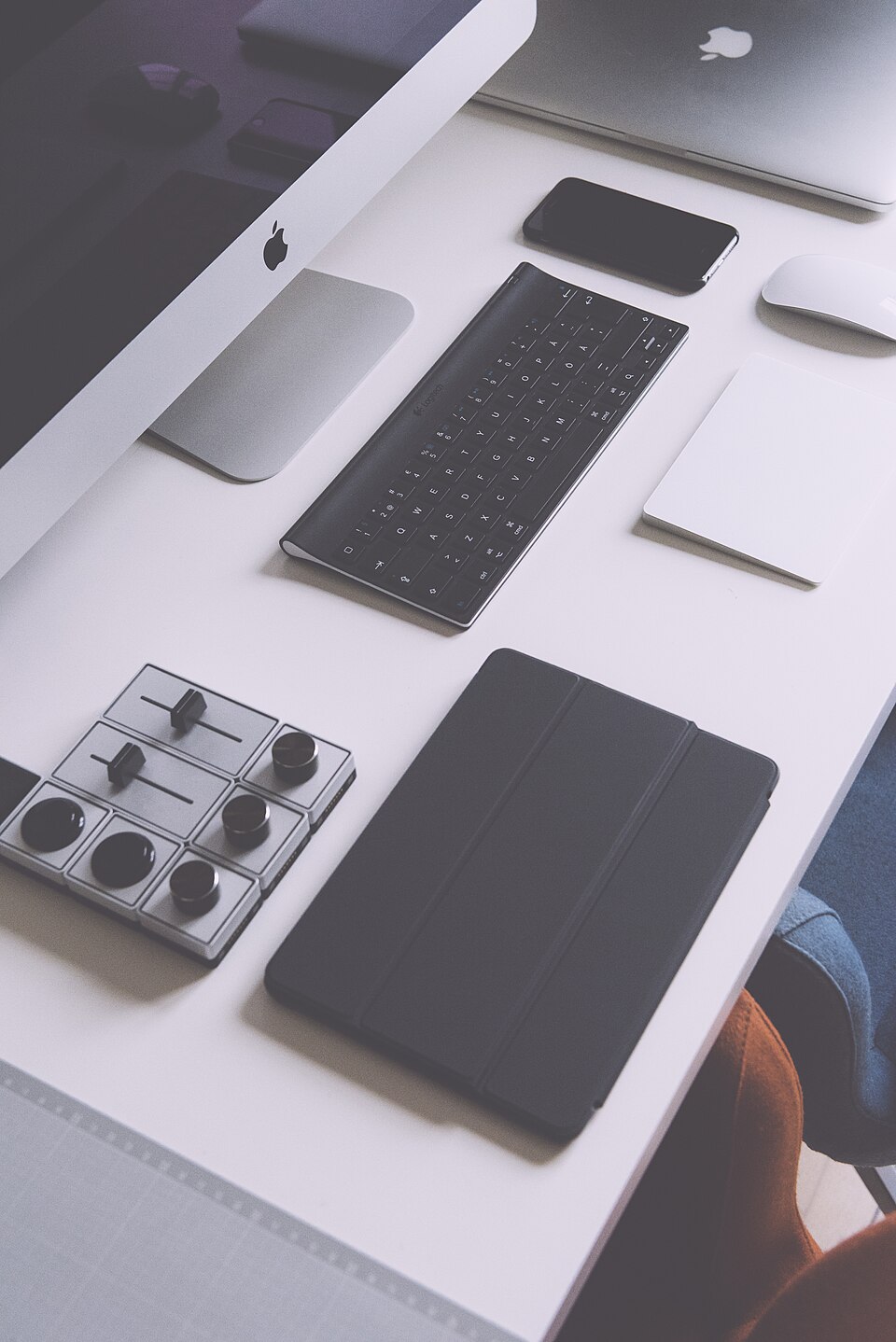 Dispositivos electrónicos y objetos de trabajo sobre una mesa.