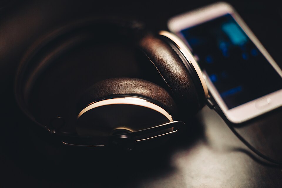 Teléfono móvil junto a unos auriculares.