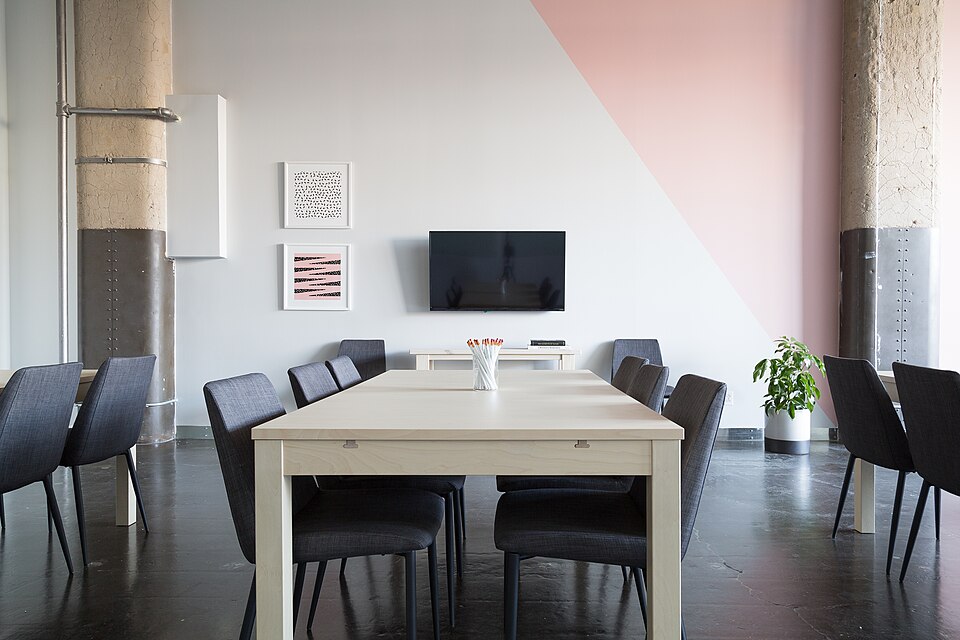 Sala de reuniones con mesa y sillas.