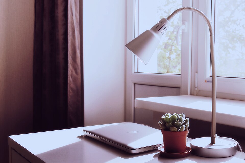 Portátil y lámpara sobre una mesa.