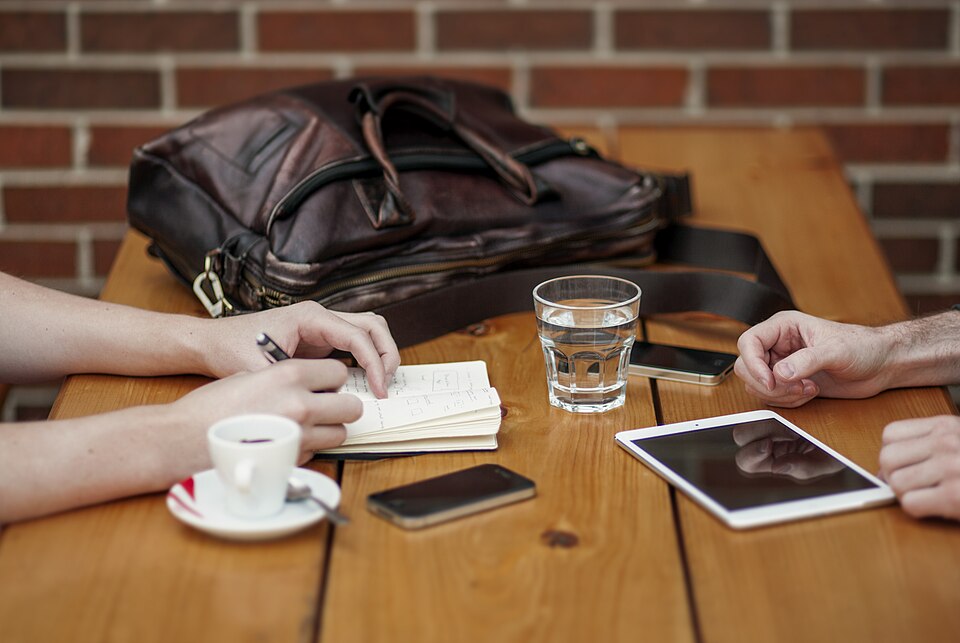 Dos personas reunidas con dispositivos móviles.