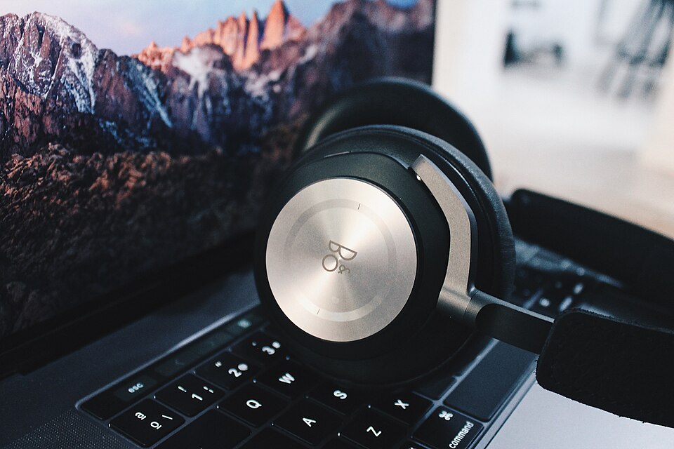 Auriculares junto a un portátil.