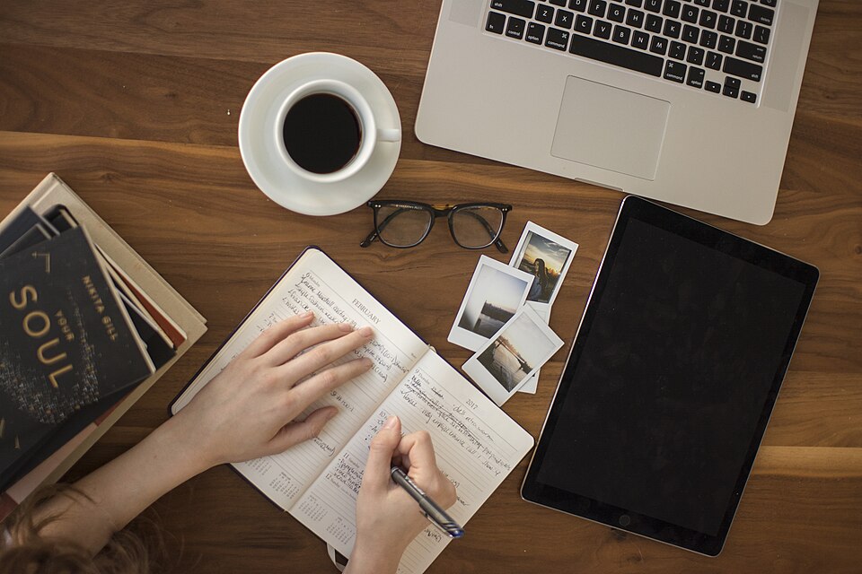 Cuaderno y café sobre una mesa.