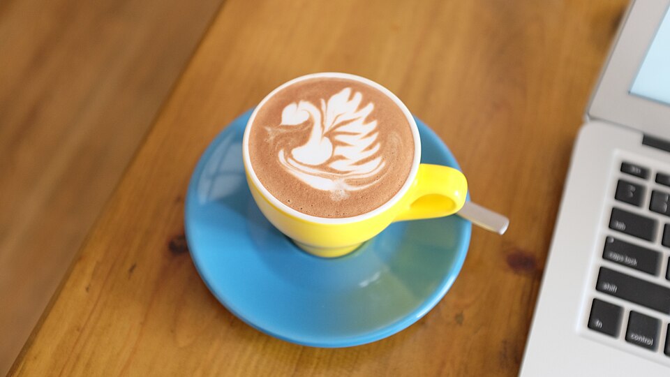 Café y portátil en una mesa.