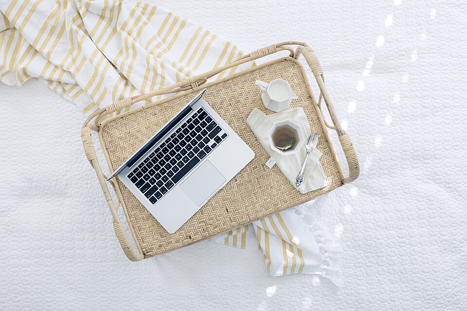 Portátil sobre una bandeja de mimbre.
